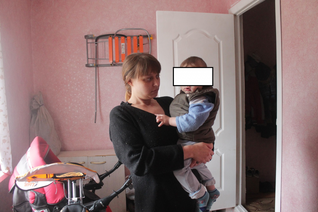 Лидия Колмогорова говорит, что “с потолка все сыпется, а по шву капает вода”. Молодая мама переживает, что может застудить ребенка. Фото: Андрей Клеймёнов, “Глобус”.